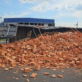 Fotos de Carreta tomba em rotatória e carga de lajotas fica espalhada na pista em Maringá